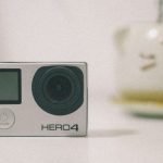 A GoPro Hero 4 action camera on a desk with soft lighting, suitable for technology themes.